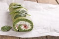 Green spinach roll with soft cheese and salmon