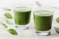 Green spinach smoothie in glass on white table Royalty Free Stock Photo