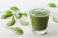 Green spinach smoothie in glass on white table Royalty Free Stock Photo
