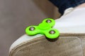 Green spinner on the foot shod in sneakers