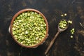 Green split peas in a bowl with a wooden spoon on a dark background. Top view. Royalty Free Stock Photo