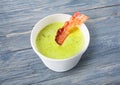 Green spring pea soup with bacon at blue wood Royalty Free Stock Photo