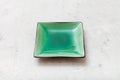 Green square saucer on gray concrete board Royalty Free Stock Photo