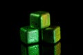 Green Stainless steel cubes simulating ice for cooling drinks on a black surface with a reflection