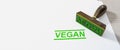 green stamp vegan on white paper background