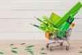 Green stationery objects in mini supermarket cart on the table.