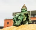 Green statue just chilling on rock