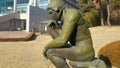 Green statue of thinker Auguste Rodin, setting naked on a rock Royalty Free Stock Photo