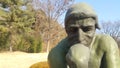 Green statue of thinker Auguste Rodin, setting naked on a rock Royalty Free Stock Photo