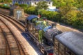 Green steam train engine and carriage on railway tracks in vivid colourful HDR Royalty Free Stock Photo