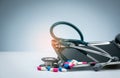 Green stethoscope with pile of antibiotic capsule pills on drug tray and spread on white table. Antimicrobial drug resistance