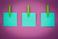 Green sticky notes on pink board. Blank stickers on clothespins on red background. Copy space. Planning concept. Blank stickers, b