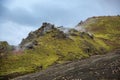 The green stony mountains Landmannalaugar against the background of a lead sky