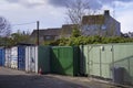 Green storage containers next to council house estate