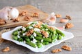 Green string beans salad with cottage cheese and walnuts on a white plate and old wooden table Closeup Royalty Free Stock Photo