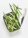 Green string beans in a vintage enameled tray on a light background, top view