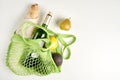 Green string eco shopping bag with vegatables, bread and bottle of vine on grey Royalty Free Stock Photo