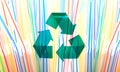 Green Stylish Recycle Arrow on Multicolored Plastic Straws Background. Reuse Sign. Environment Care Concept