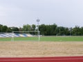 A bright green football field on a natural background. A modern football field with gates, soffits, and plastic seats. Royalty Free Stock Photo