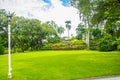 Green summer public park garden with blue sky in the cloudy day. Beautiful day light in public park with green grass field and fre Royalty Free Stock Photo