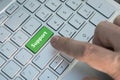 green support keyboard button, A male finger presses a color button on a gray silver keyboard of a modern laptop. Button with