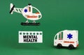 On a green surface, an ambulance car and a helicopter with a sign - MENTAL HEALTH Royalty Free Stock Photo