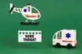 On a green surface, an ambulance car and a helicopter with a sign - SORE THROAT Royalty Free Stock Photo