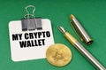 On a green surface, a bitcoin coin, a pen and a sheet of paper with the inscription - My crypto wallet