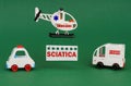 On a green surface, cars and an ambulance helicopter with a sign - SCIATICA