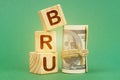 On a green surface, dollars and cubes with the inscription - BRU