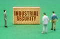 On the green surface are figures of people and a sign with the inscription - Industrial Security Royalty Free Stock Photo