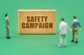 On the green surface are figures of people and a sign with the inscription - Safety Campaign Royalty Free Stock Photo