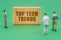 On the green surface are figures of people and a sign with the inscription - Top Tech Trends