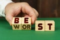 On a green surface, a man puts cubes with the inscription - BEST, WORST