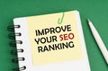 On a green surface, a pen, a notepad with stickers and the inscription - Improve Your Seo Ranking