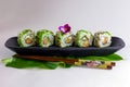 Green sushi rolls on a black dish with chopsticks Royalty Free Stock Photo