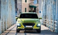 Green SUV car with lights on standing on metal bridge