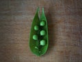 Green sweat pea pod on cutting board.