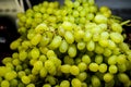 Green sweet grapes on a branch on a shelf in a store