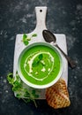 Green sweet pea and mint soup with cream and olive oil drizzle served with grilled ciabatta toasts Royalty Free Stock Photo