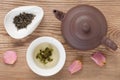 Green tea brewed in tea bowl served with tea tableware, top view on rustic wooden table decorated rose petals Royalty Free Stock Photo