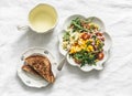 Green tea, crispy wholegrain toast and salad with canned tuna, boiled egg, arugula, cherry tomatoes and corn on a light background