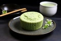 a green tea-flavored cupcake on a black ceramic plate