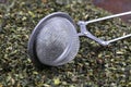 Green tea with herbs in sieve on a wooden board Royalty Free Stock Photo