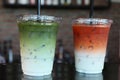 Green tea and iced milk tea with ice  Drinks put into plastic cups, ready to drink in a cafe, close-up. Royalty Free Stock Photo