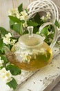 Green tea with jasmine in glass teapot on wooden shabby table Royalty Free Stock Photo