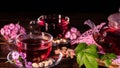 Green tea leaves or leaves of medicinal herbs lie on the table with a teapot and mugs of red tea, cashew nuts and clove flowers.