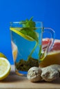 Green tea with lemon, ginger, grapefruit, mint. Blue background Royalty Free Stock Photo