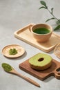 Green tea matcha in a wooden cup with German cake on the brown mat close-up Royalty Free Stock Photo