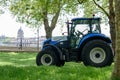 Green team tractor equipment agricultural vehicle works in the park. Selective focus. London, UK - May 05, 2022